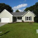 Closed Garage Door, Driveway, and Trimmed Grass in the Front yard