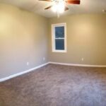 A Wood Flooring Empty Room With a Single Panel Window