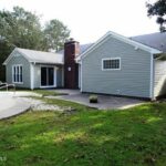 Full View of Garage, Front Yard, and Pool in the Side