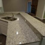 Sink, Concrete Counter, and View of the Brick Fireplace