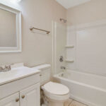 A White Cupboards Bathroom With Tiled Space