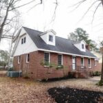 White Top and Red Bottom Brick Home with Stairs in the Entrance