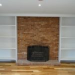 A Closer View of the Brick Fireplace and Shelves on Both Sides