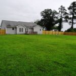 A Small Deck, Greenery, and Fence Around the Home