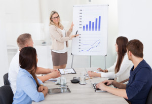 Five People in Boardroom, A Woman Showing Presentation