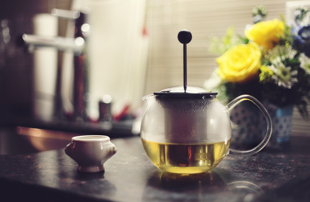 A Beverage Placed on Countertop and Yellow Flowers in the Back