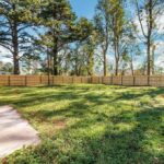 Large Ground, Fence, and Big Trees Beyond the Boundary