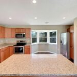 Granite Platform, Wooden Cabinets, and Appliances in the Kitchen