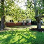 Two Large Trees and Trimmed Grass in Front of the House