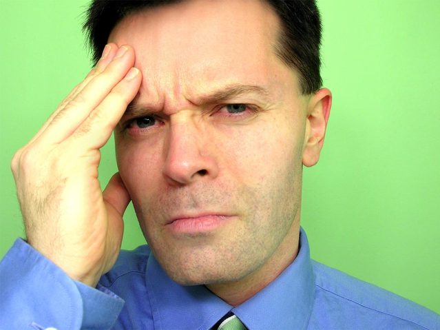 A Tensed Man Rubbing His Head, Wearing A Formal Dress