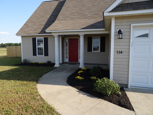 Pillars, Red Gate and Driveway Through Trimmed Grasses and Plants