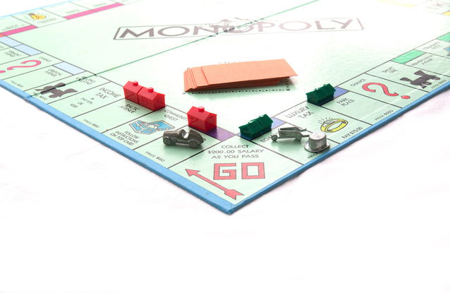 A Board Game with Tiny House Structures and Monopoly Written Over