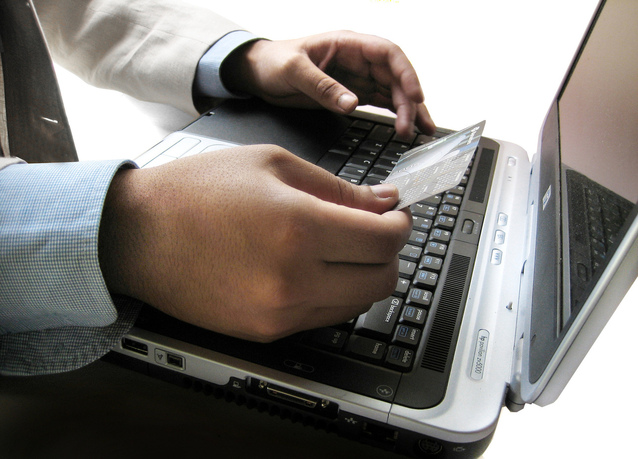 A Man in Full Sleeve Shirt Doing Online Transaction Using Card on Laptop