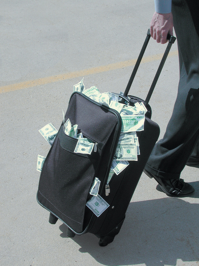 A Man Dragging a Strolley Full of Cash on A Road