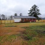 Brick and Vinyl Home with Fence Around the Front yard