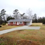 Brick Home, Driveway, and Dense Vegetation in the Back