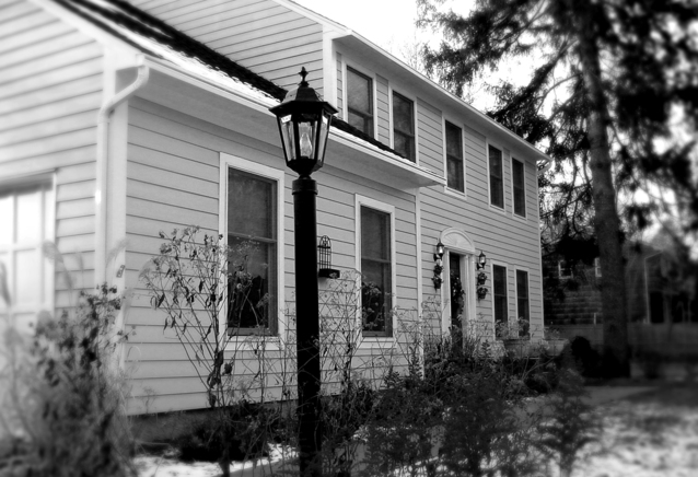 Black and White View of a Home in Winter with a Light Pole