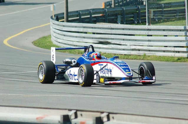 Formula One Racing Car on the Track and Fence