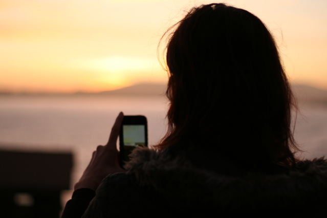 A Millennial Browsing Smartphone Wearing Winter Garments