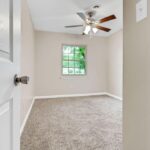 An Open Gate Toward Redone Bedroom with Window and Fan